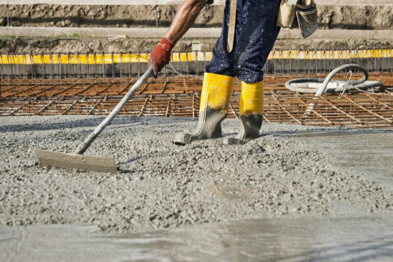 a bricklayer who level the freshly poured concrete to lay the foundations of a building